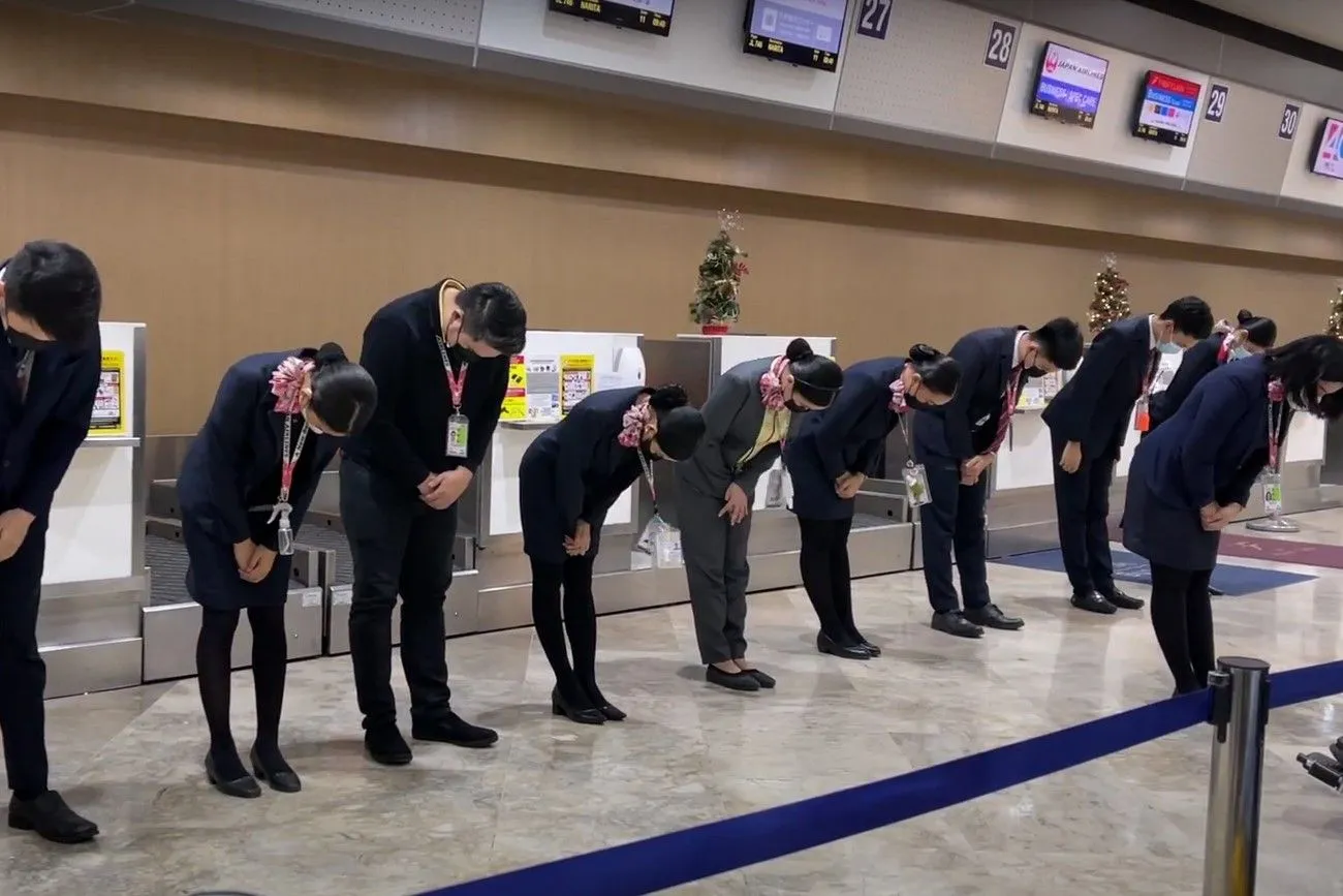 38. Airline staff members bow before customers.jpg?format=webp